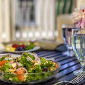 a delicious salad and a glass of water with a lemon slice await diners at the Hearth at Drexel