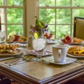 a dining table set for four with a variety of items from our menu that's created to be delicious and nutritious for the needs of seniors
