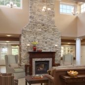 The Tuscan living room has a cozy fireplace and comfortable seating for our senior residents to enjoy time with their neighbors