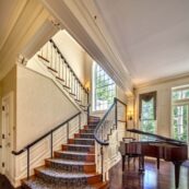 entryway with piano and main staircase with bannister and inner rail to provide safety for our senior residents