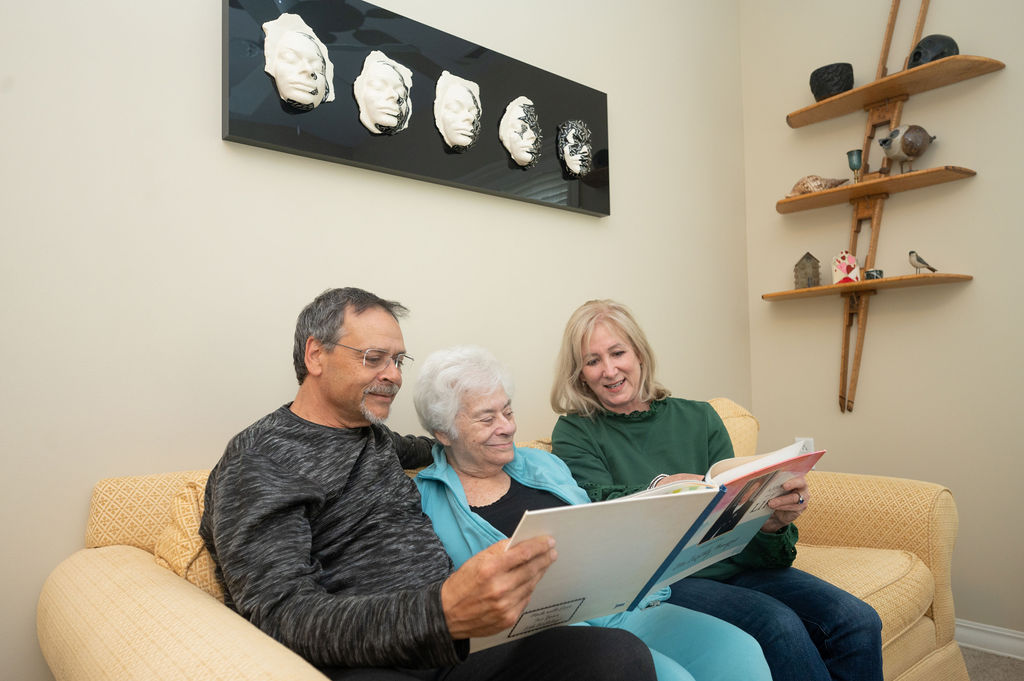 a resident enjoys viewing family photos with her adult children