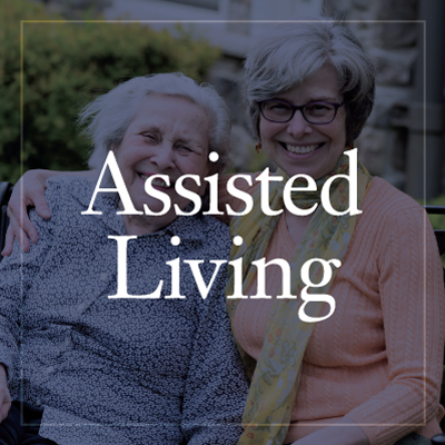 two happy senior residents smile. The image has a grey screen over it with text reading "Assisted Living"