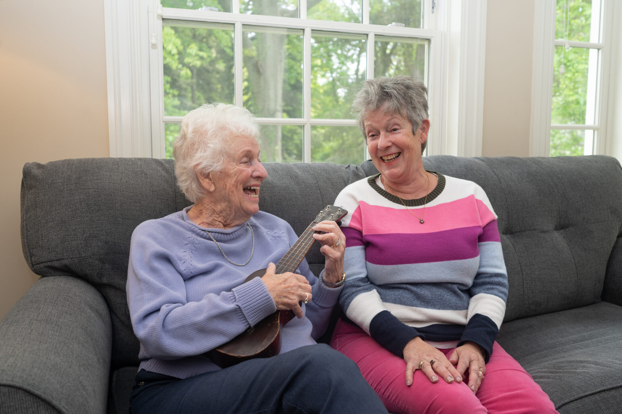 Chloe plays the ukulele as her daughter, Shelley, watches.