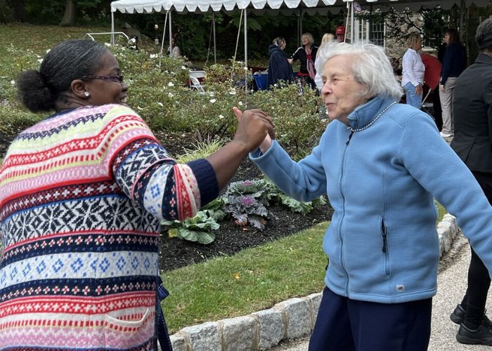 A resident dances with a team member at The Hearth at Drexel family picnic