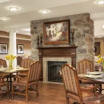 One of the dining rooms at the Hearth at Drexel. It features a large stone fireplace, good lighting, and beauitful art