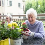 The Hearth at Drexel residents hold a flower pot during spring.
