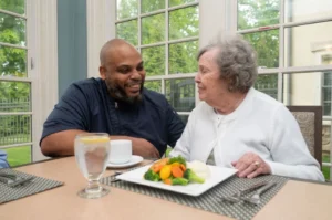 A plate of fresh vegetables and seafood sits in front of the hearth at drexel's chef and a resident in the dining room